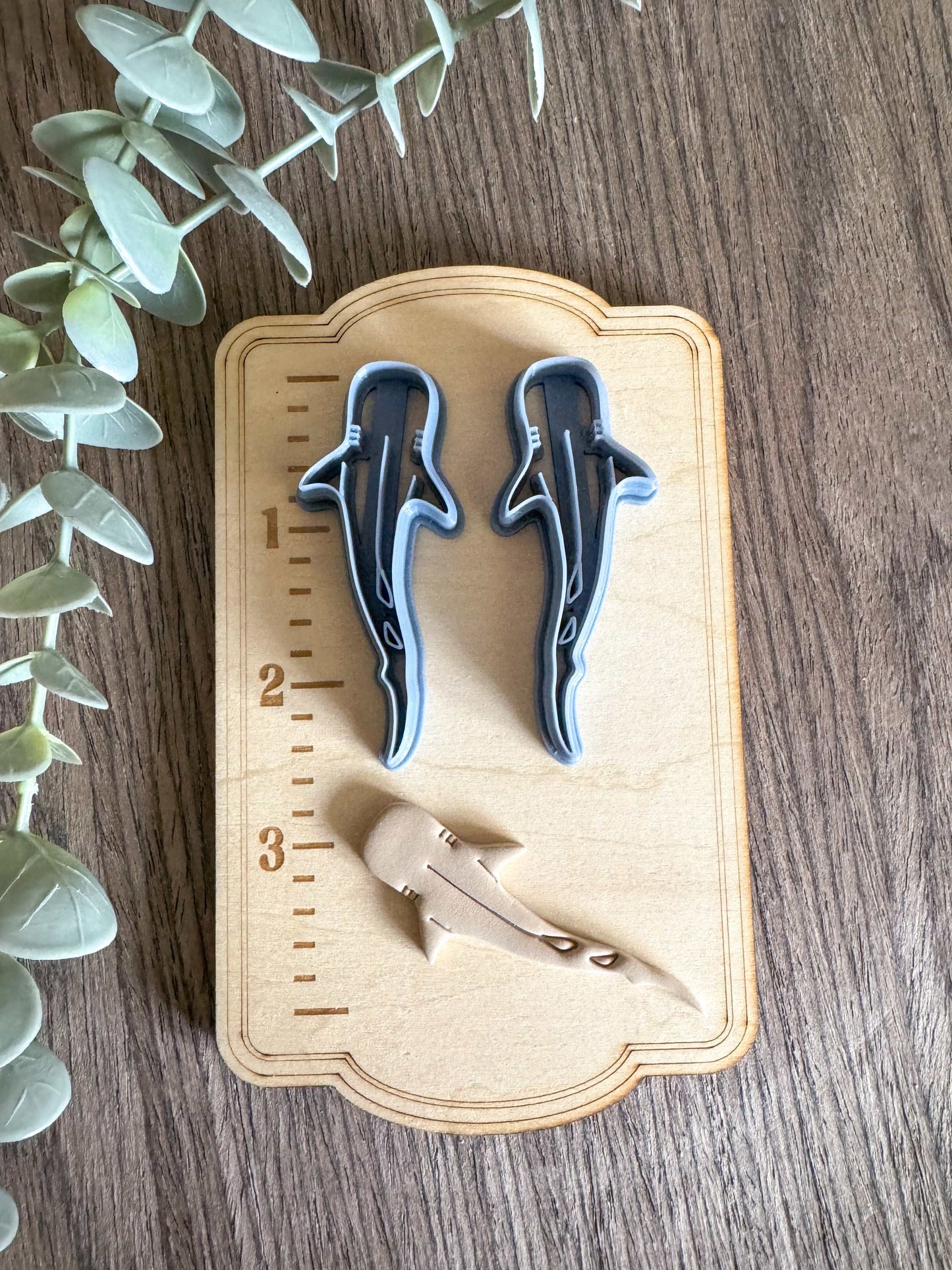 Whale shark clay cutters on wooden measuring board.