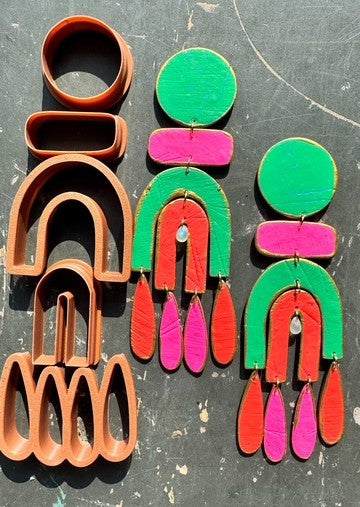 Rusted Chandelier polymer clay cutters with colorful pink, green, and orange statement earring designs on dark background
